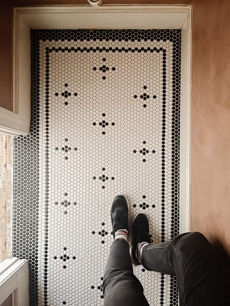 small bathroom with vintage black and white penny tiles in a custom pattern