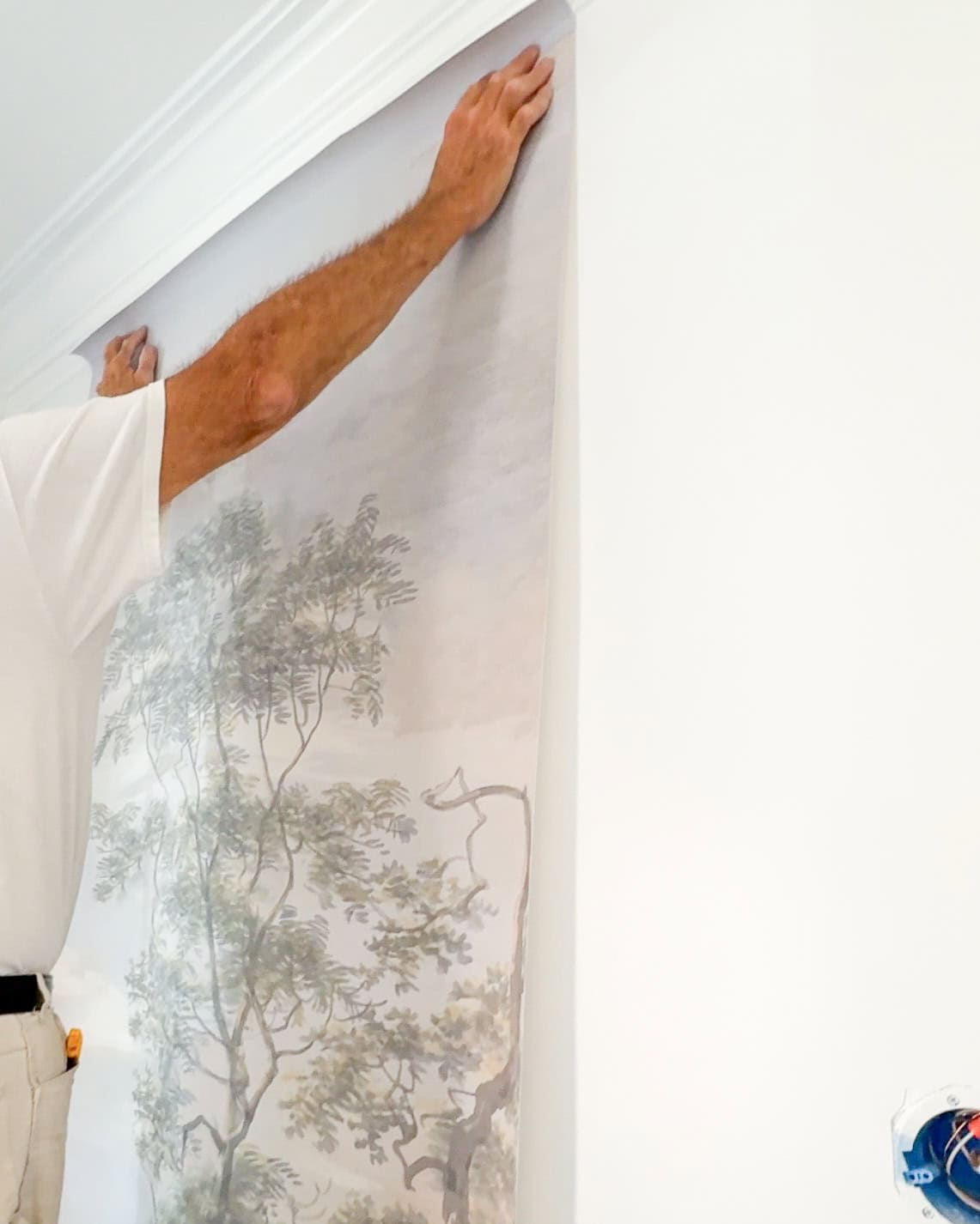 mural wallpaper being installed in a dining room