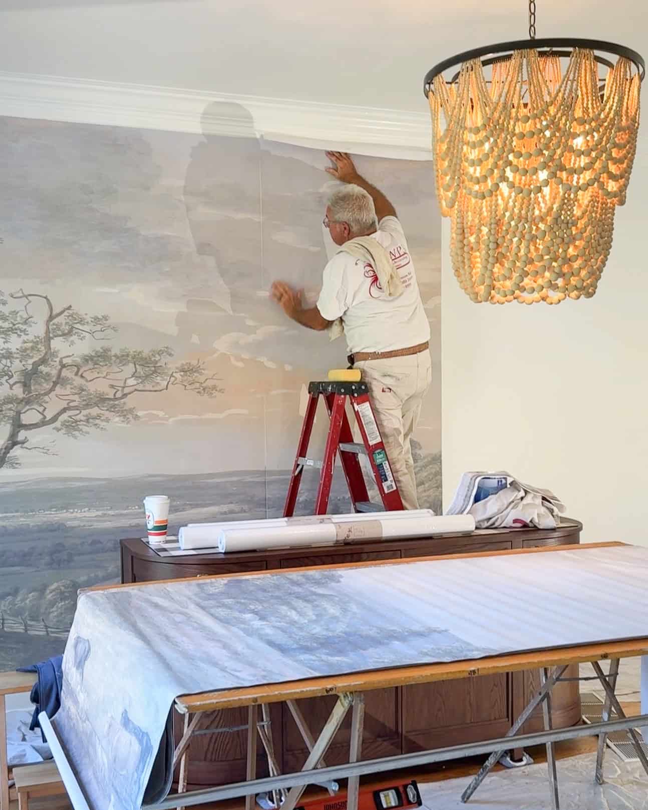mural wallpaper being installed in a dining room